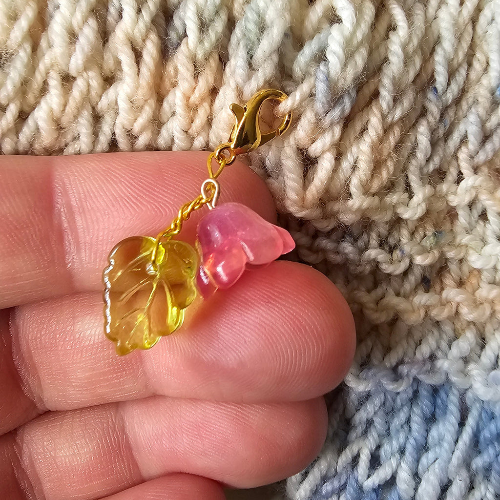 Gold leaf charm on a hand with a textured fabric background